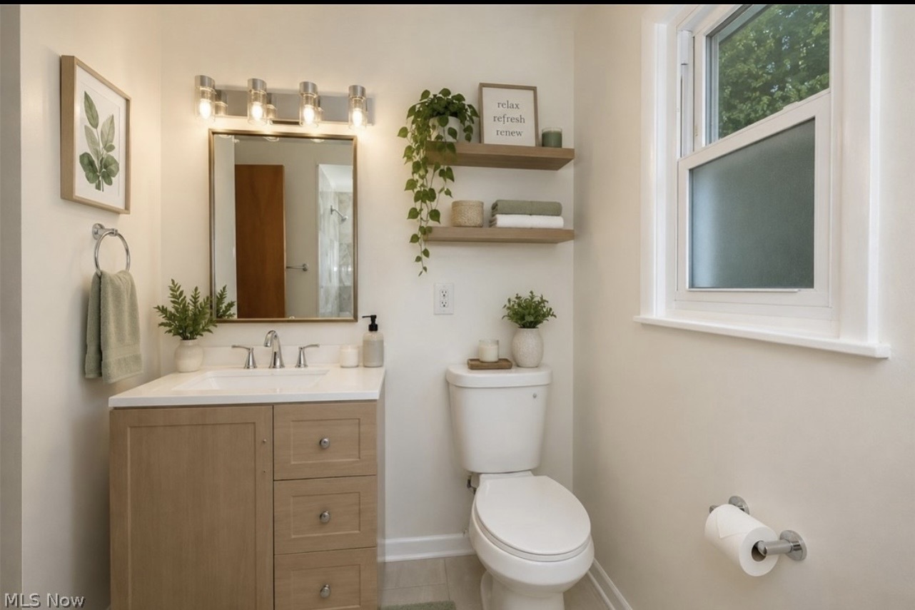Ohio bathroom after renovation, with updated vanity, mirror, lighting, and shelving