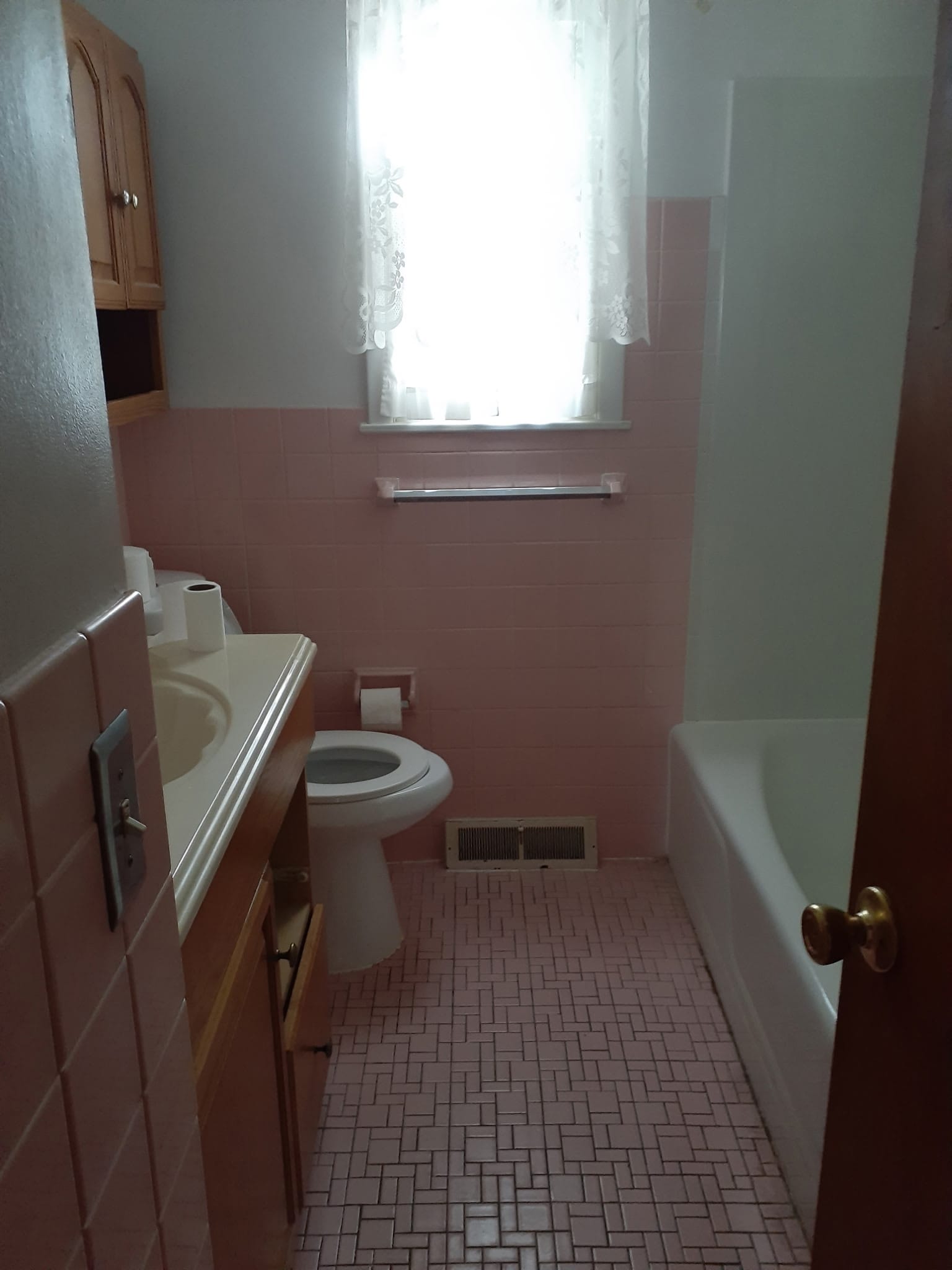 Ohio bathroom before renovation, with pink tile and older fixtures