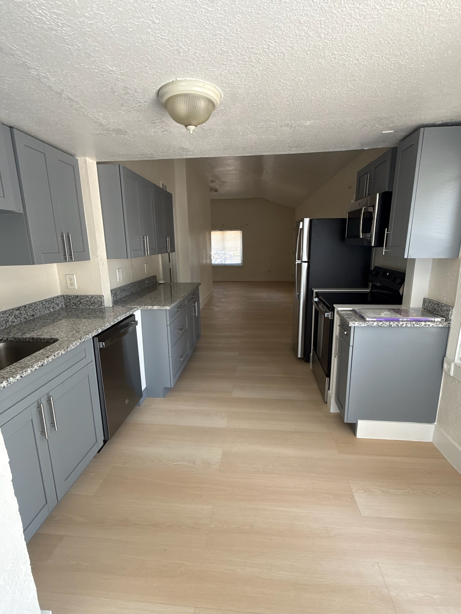 St. Petersburg kitchen after renovation, with gray cabinetry, stone countertops, and new flooring