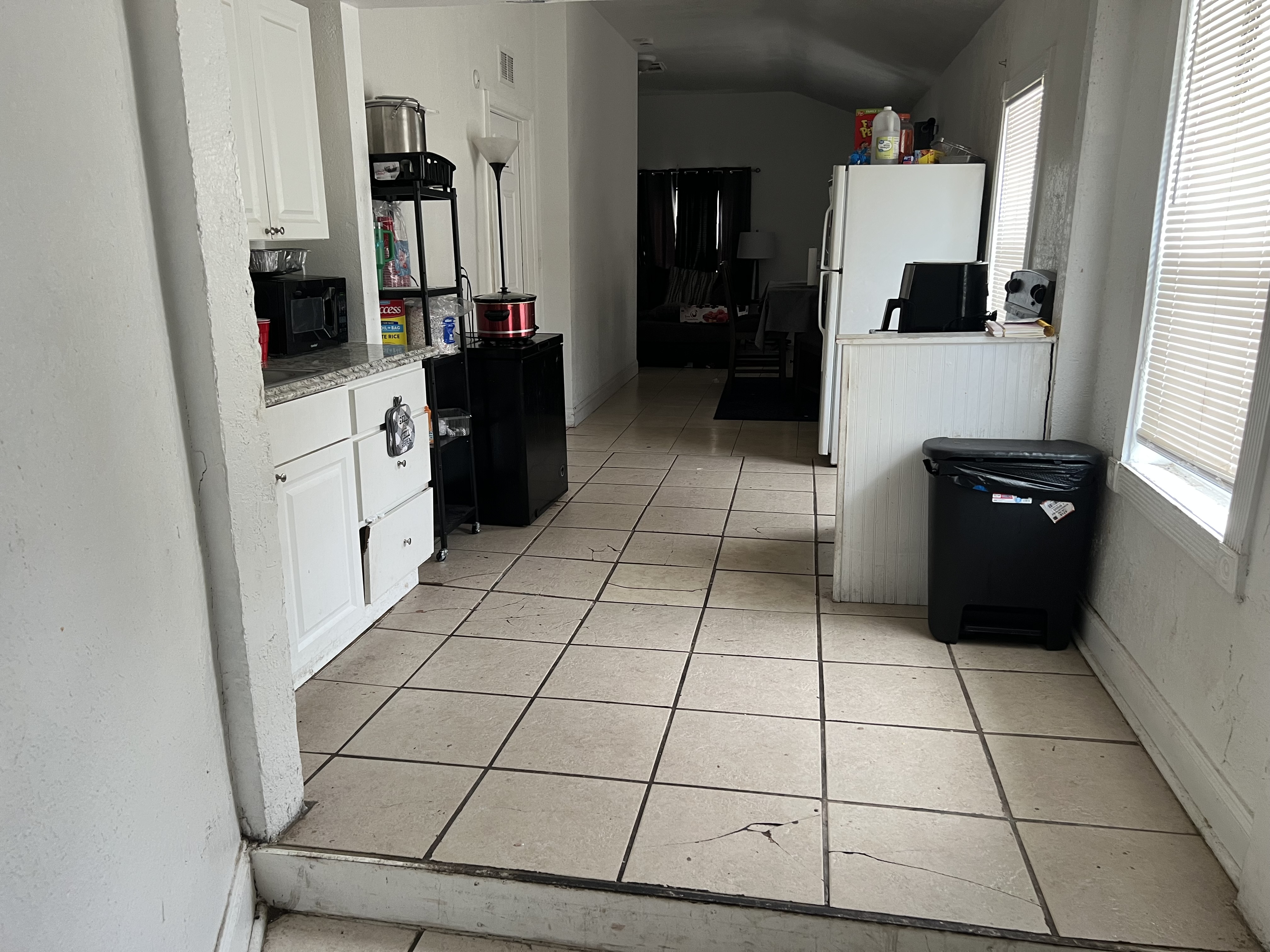 St. Petersburg kitchen before renovation, with older cabinetry, tile flooring, and appliances